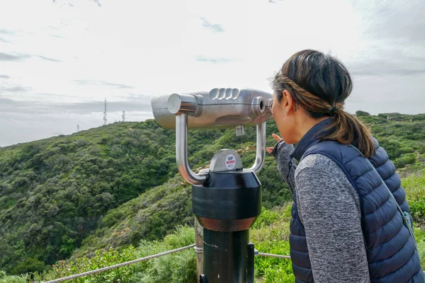 San Diego, Kaliforniya, ABD noktası Loma Yarımadası'nın uç üzerinde dürbün teleskop içinde arıyorsunuz Asya sportif kadın. San Diego şehir ve bay gözlemlemek için otomatik dürbün arayan genç kadın. işletilen sikke dürbün.
