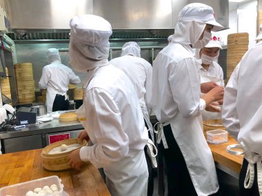 Şefler tarafından bir restoranda geleneksel bambu vapurları Çin köfte yemek vardır. Dim Sum şefler sarma mantı ünlü restoranda Din Tai Fung çalışma. Pekin, Çin. 09/10/2018