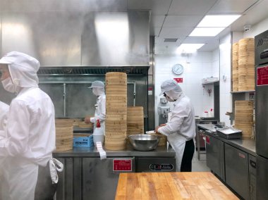 Şefler tarafından bir restoranda geleneksel bambu vapurları Çin köfte yemek vardır. Dim Sum şefler sarma mantı ünlü restoranda Din Tai Fung çalışma. Pekin, Çin. 09/10/2018