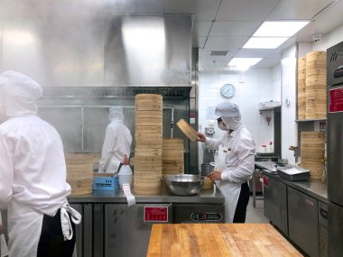 Şefler tarafından bir restoranda geleneksel bambu vapurları Çin köfte yemek vardır. Dim Sum şefler sarma mantı ünlü restoranda Din Tai Fung çalışma. Pekin, Çin. 09/10/2018
