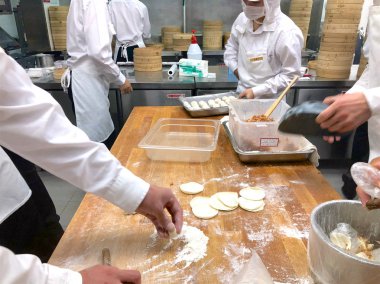 Şefler tarafından bir restoranda geleneksel bambu vapurları Çin köfte yemek vardır. Dim Sum şefler sarma mantı ünlü restoranda Din Tai Fung çalışma. Pekin, Çin. 09/10/2018