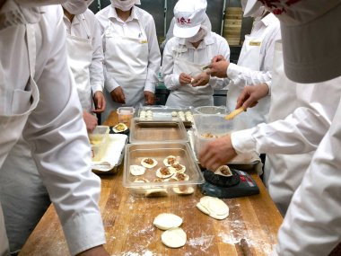 Şefler tarafından bir restoranda geleneksel bambu vapurları Çin köfte yemek vardır. Dim Sum şefler sarma mantı ünlü restoranda Din Tai Fung çalışma. Pekin, Çin. 09/10/2018