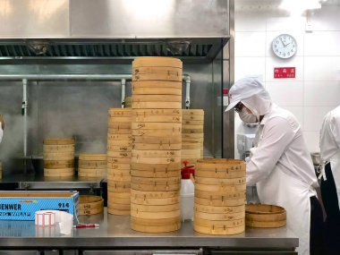 Şefler tarafından bir restoranda geleneksel bambu vapurları Çin köfte yemek vardır. Dim Sum şefler sarma mantı ünlü restoranda Din Tai Fung çalışma. Pekin, Çin. 09/10/2018