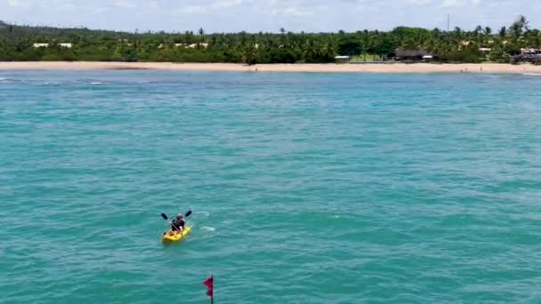 강력한 젊은이의 바다의 청록색 물에서 카약을 조감도 휴가입니다 프라이아 브라질 — 비디오