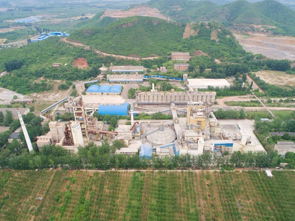 Aerial view of factory in the middle of thr mountain and green farm land, in the area of Huaibei, China. Industrial factory, pollution.