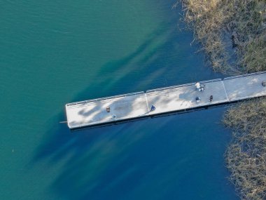 Miramar gölü, San Diego, Kaliforniya'da balık yakalamaya çalışan balıkçılar ve olta çubukları ile ahşap iskelehavadan görünümü. Abd. Tekne, balıkçılık, motorlu tekne dahil rekreasyon sitesi.  