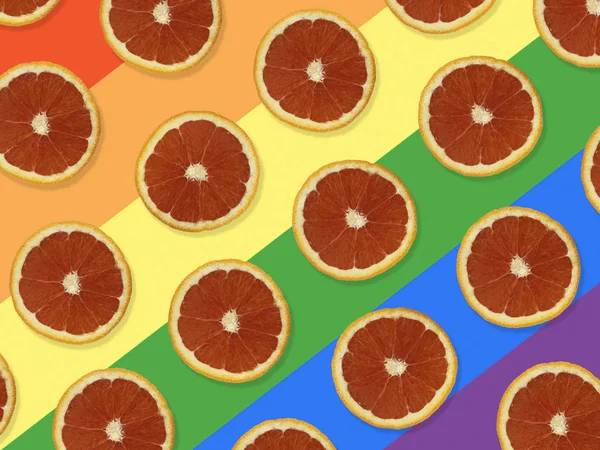 Creative pattern made of red oranges. top view of colorful fruit pattern of fresh red orange slices on colorful background. The rainbow flag, LGBT background