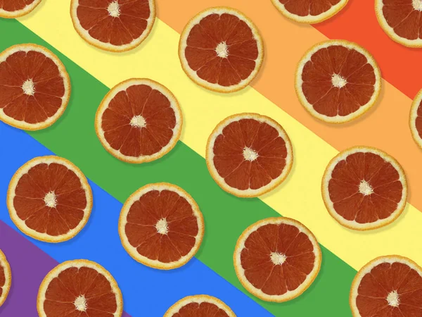 Creative pattern made of red oranges. top view of colorful fruit pattern of fresh red orange slices on colorful background. The rainbow flag, LGBT background