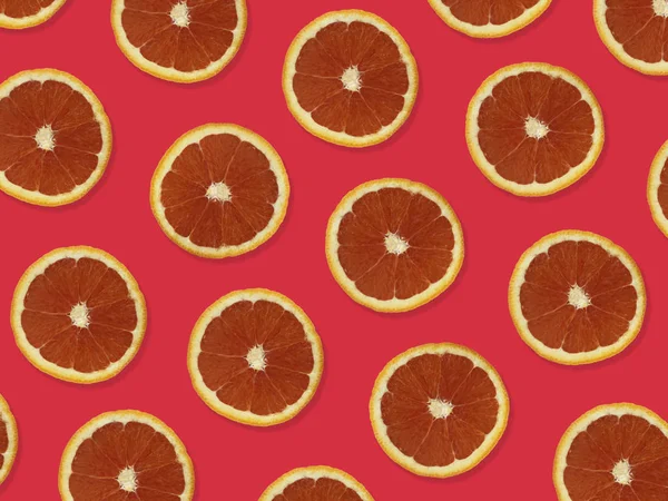 Creative pattern made of red oranges. top view of colorful fruit pattern of fresh red orange slices on colorful background.