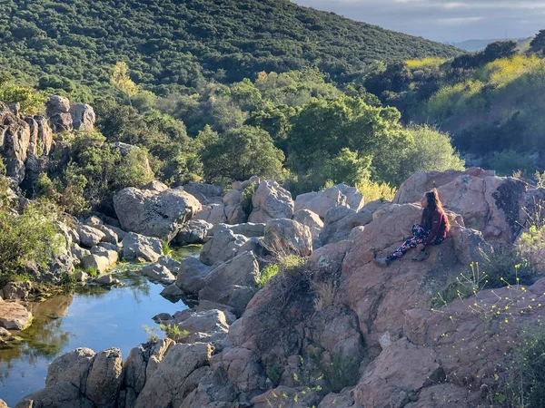 Junge Frau Sitzt Auf Einem Felsen Und Blickt Zum Horizont — Stockfoto