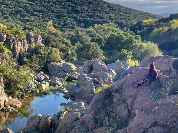 Junge Frau Sitzt Auf Einem Felsen Und Blickt Zum Horizont — Stockfoto