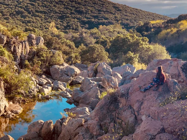 Junge Frau Sitzt Auf Einem Felsen Und Blickt Zum Horizont — Stockfoto