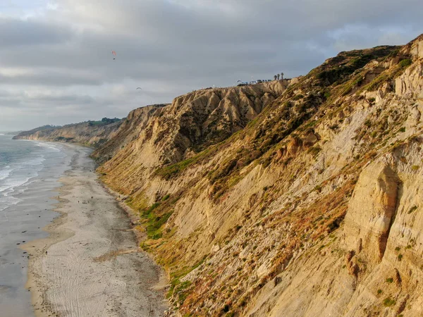 黄色い砂岩の崖と波が日没時にビーチを急いで太平洋の海岸線の航空写真 ブラックビーチ トーリーパインズ州自然保護区 サンディエゴ カリフォルニア アメリカ — ストック写真