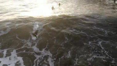 Gün batımından önce San Clemente İskelesi'nin yanındaki dalgaların keyfini çıkaran sörfçülerin havadan görünümü. San Clemente city, Orange County, Kaliforniya, Abd