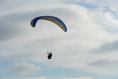 Adam spor yapıyor (para-planör). Bulutlu gökyüzünde bir adam yamaç paraşütü. Paragliding aşırı bir spor ve rekreasyon olduğunu. Torrey Pines Gliderport. San Diego 'da. Kaliforniya, ABD. 