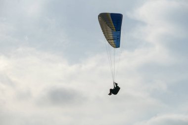 Adam spor yapıyor (para-planör). Bulutlu gökyüzünde bir adam yamaç paraşütü. Paragliding aşırı bir spor ve rekreasyon olduğunu. Torrey Pines Gliderport. San Diego 'da. Kaliforniya, ABD. 
