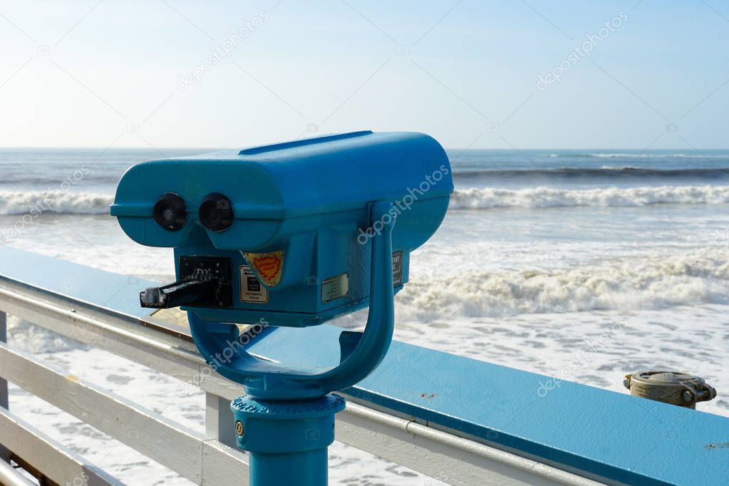 Sightseeing binoculars with Beach background San Clemente Pier in Orange County, California, USA. Travel destination in the South West Coast.