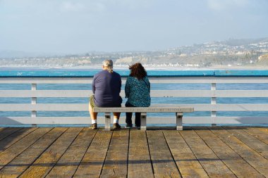 San Clemente İskelesi'nin manzarasına bakan çift ya da aileler. Gün batımından önce rahatlatıcı bir zaman. San Clemente city, Orange County, Kaliforniya, Abd