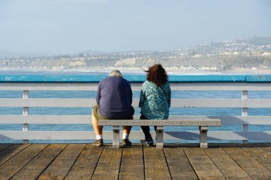 San Clemente İskelesi'nin manzarasına bakan çift ya da aileler. Gün batımından önce rahatlatıcı bir zaman. San Clemente city, Orange County, Kaliforniya, Abd