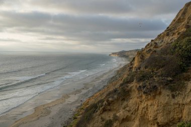 Sarı kumtaşı kayalıklar ve dalgalar gün batımı sırasında plaj acele ile Pasifik kıyı şeridihavadan görünümü. Black Beach, Torrey Pines State Natural Reserve, San Diego, Kaliforniya, Amerika Birleşik Devletleri