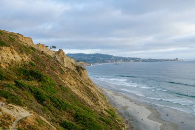 Sarı kumtaşı kayalıklar ve dalgalar gün batımı sırasında plaj acele ile Pasifik kıyı şeridihavadan görünümü. Black Beach, Torrey Pines State Natural Reserve, San Diego, Kaliforniya, Amerika Birleşik Devletleri