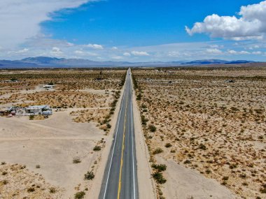 Joshua Tree Park'ın yanındaki uçsuz bucaksız çöl düz yolunun havadan görünümü. Abd. Arizona yönüne doğru çöle doğru giden uzun düz asfalt yol.