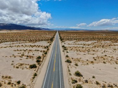 Joshua Tree Park'ın yanındaki uçsuz bucaksız çöl düz yolunun havadan görünümü. Abd. Arizona yönüne doğru çöle doğru giden uzun düz asfalt yol.