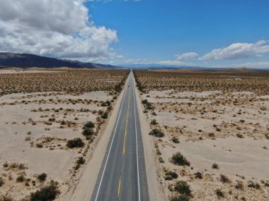 Joshua Tree Park'ın yanındaki uçsuz bucaksız çöl düz yolunun havadan görünümü. Abd. Arizona yönüne doğru çöle doğru giden uzun düz asfalt yol.