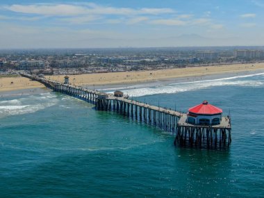 Huntington İskelesi'nin havadan görünümü, güneşli yaz günlerinde sahil ve sahil şeridi, Los Angeles'ın güneydoğusu. California. sörfçü ve turist için hedef.