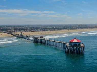 Huntington İskelesi'nin havadan görünümü, güneşli yaz günlerinde sahil ve sahil şeridi, Los Angeles'ın güneydoğusu. California. sörfçü ve turist için hedef.