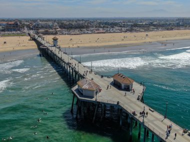 Huntington İskelesi'nin havadan görünümü, güneşli yaz günlerinde sahil ve sahil şeridi, Los Angeles'ın güneydoğusu. California. sörfçü ve turist için hedef.