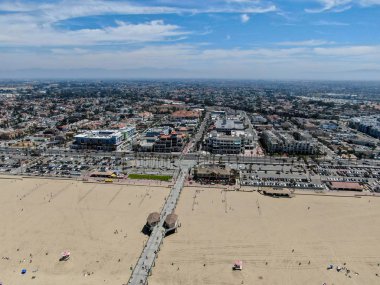 Huntington İskelesi'nin havadan görünümü, güneşli yaz günlerinde sahil ve sahil şeridi, Los Angeles'ın güneydoğusu. California. sörfçü ve turist için hedef.