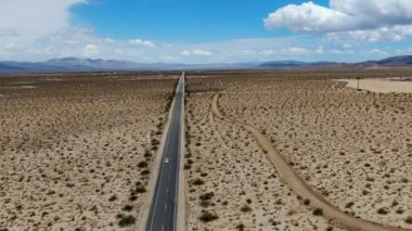 Joshua Tree Park'ın yanındaki uçsuz bucaksız çöl düz yolunun havadan görünümü. Abd. Arizona yönüne doğru çöle doğru giden uzun düz asfalt yol.