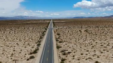 Joshua Tree Park'ın yanındaki uçsuz bucaksız çöl düz yolunun havadan görünümü. Abd. Arizona yönüne doğru çöle doğru giden uzun düz asfalt yol.