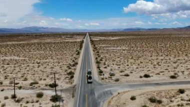 Joshua Tree Park'ın yanındaki uçsuz bucaksız çöl düz yolunun havadan görünümü. Abd. Arizona yönüne doğru çöle doğru giden uzun düz asfalt yol.