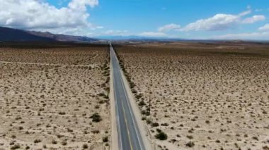 Joshua Tree Park'ın yanındaki uçsuz bucaksız çöl düz yolunun havadan görünümü. Abd. Arizona yönüne doğru çöle doğru giden uzun düz asfalt yol.