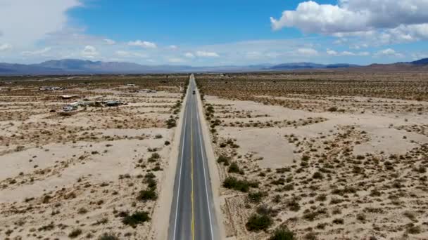ジョシュアツリーパークの隣の無限の砂漠のまっすぐな道の航空写真 アリゾナ方面に砂漠に向かう長いまっすぐなターマック道路 — ストック動画