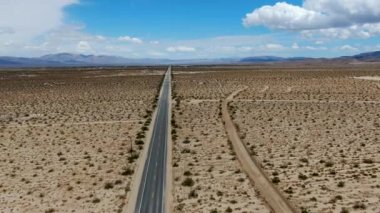 Joshua Tree Park'ın yanındaki uçsuz bucaksız çöl düz yolunun havadan görünümü. Abd. Arizona yönüne doğru çöle doğru giden uzun düz asfalt yol.