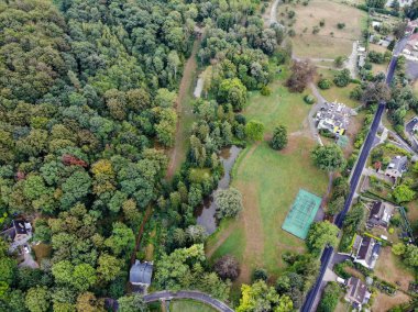 Walloon Brabant, Belçika'da kırsal alanın havadan görünümü, yeşil bahar sezonunda ormanla çevrili bahçeli lüks villalar