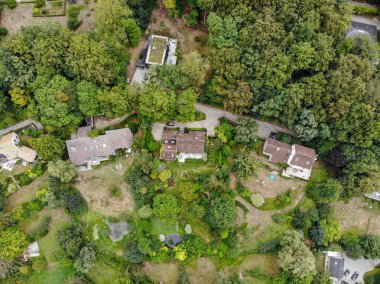 Walloon Brabant, Belçika'da kırsal alanın havadan görünümü, yeşil bahar sezonunda ormanla çevrili bahçeli lüks villalar