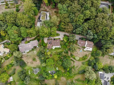 Walloon Brabant, Belçika'da kırsal alanın havadan görünümü, yeşil bahar sezonunda ormanla çevrili bahçeli lüks villalar