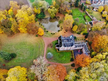 Sonbahar sezonunda ormanla çevrili çiftlik tarzı kalenin havadan görünümü, Belçika, Valon Brabant. 