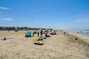 Turist ve sahilde aileler Huntington Beach, California güzel yaz günü zevk. Abd