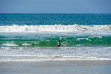 Huntington Beach, Kaliforniya'da dalgalar ve güzel yaz günü zevk plajda genç çocuk. Abd