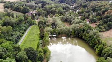 Yeşil bahar sezonunda göl, orman ve lüks villalar ile kırsal alanın havadan görünümü. Walloon Brabant kırsal alanı, Belçika,