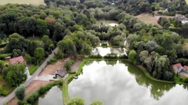 Yeşil bahar sezonunda göl, orman ve lüks villalar ile kırsal alanın havadan görünümü. Walloon Brabant kırsal alanı, Belçika,