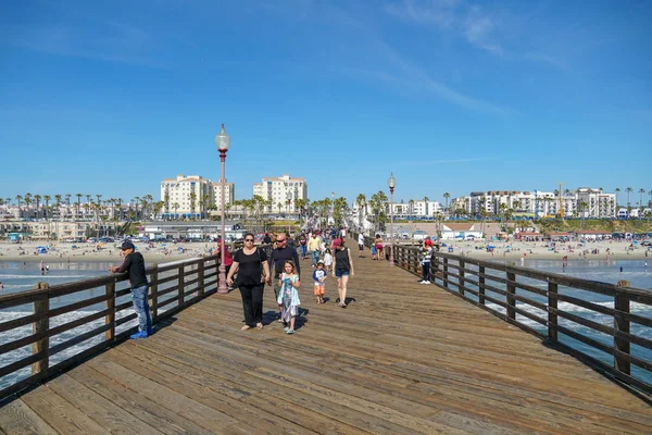 游客在蓝色夏季当天在海边码头散步 加州圣迭戈县北部 美国西部海岸线上的木制码头 以渔民闻名 — 图库照片