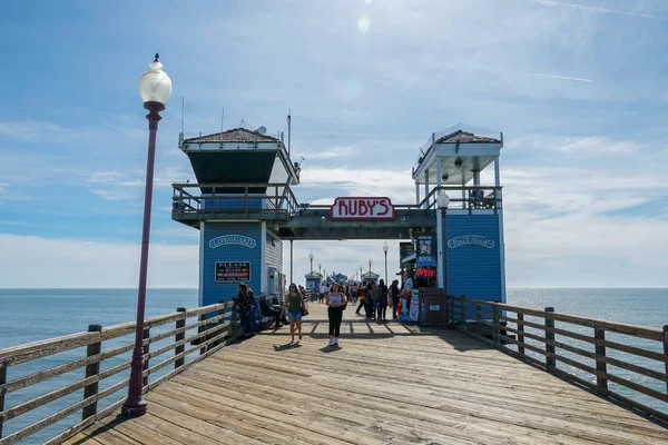 Mavi yaz gününde Oceanside İskelesi'nde yürüyen turist, Oceanside, kuzey San Diego County, Kaliforniya. Batı Amerika Birleşik Devletleri kıyı şeridinde ahşap iskele. Balıkçı ile ünlüdür. 