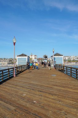 Mavi yaz gününde Oceanside İskelesi'nde yürüyen turist, Oceanside, kuzey San Diego County, Kaliforniya. Batı Amerika Birleşik Devletleri kıyı şeridinde ahşap iskele. Balıkçı ile ünlüdür. 