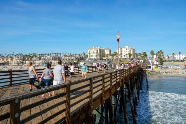 Mavi yaz gününde Oceanside İskelesi'nde yürüyen turist, Oceanside, kuzey San Diego County, Kaliforniya. Batı Amerika Birleşik Devletleri kıyı şeridinde ahşap iskele. Balıkçı ile ünlüdür. 